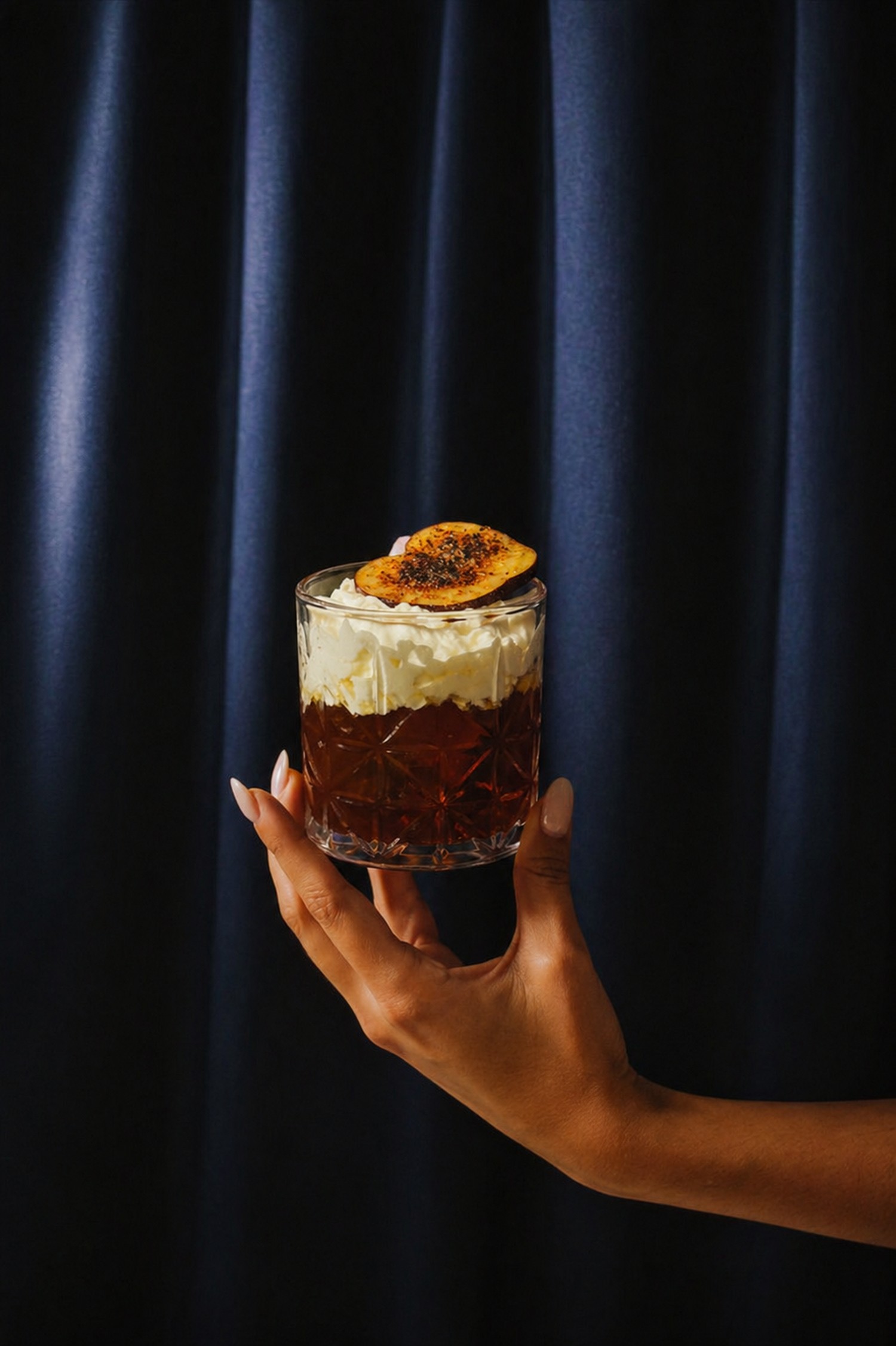 S'more Old Fashioned cocktail against the navy curtain at BARROOM